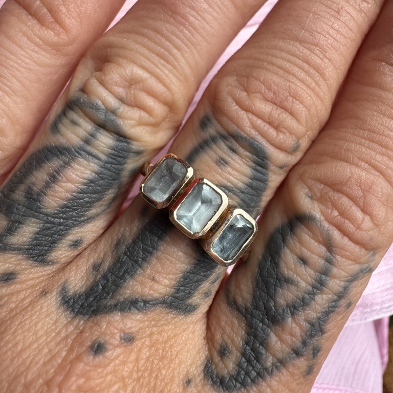9ct gold three-stone ring with pale blue gemstones